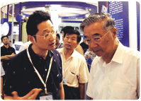 2009年6月，国家金卡工程协调小组首任组长，原全国政协副主席胡启立在华虹设计总经理李荣信的陪同下莅临华虹展位参观指导（右一：胡启立，左一：李荣信）