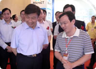 2010年9月，中央政治局委员、中央书记处书记、中央组织部部长李源潮(左)在华虹设计副总经理谢文录(右)陪同下参观了公司展位